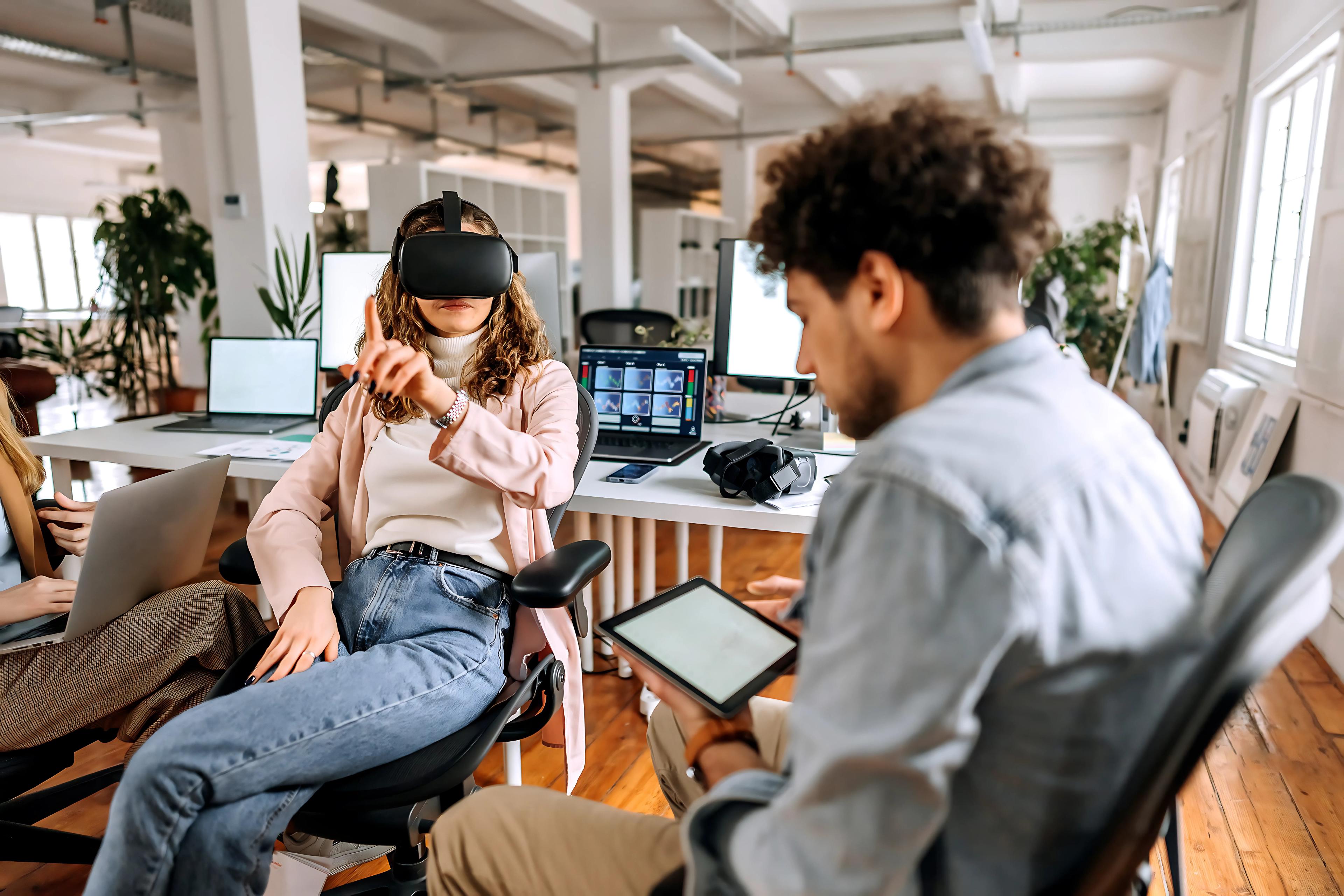 A person with a tablet and another with a VR device